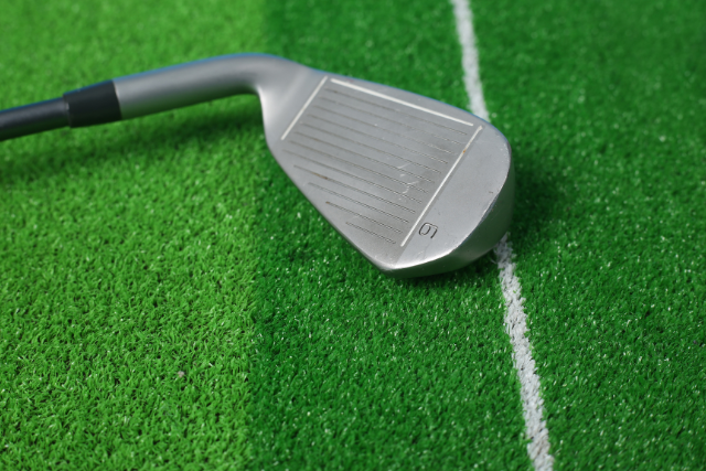 Golf club positioned on artificial turf