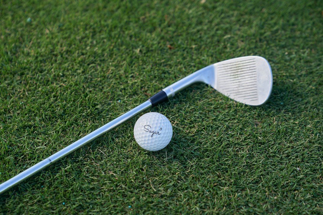 Golf club and ball resting on grass