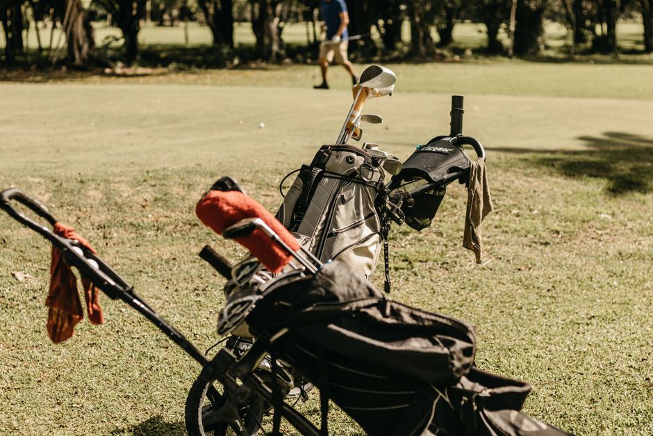 Golf bag on a push cart parked on a sunny fairway