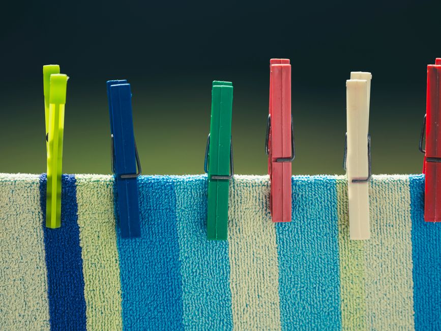 Five colored clothespins on striped towel
