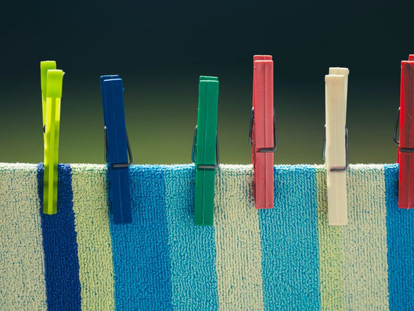 Five colored clothespins on striped towel