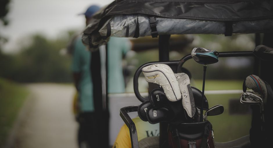 Golf clubs in a cart on a course