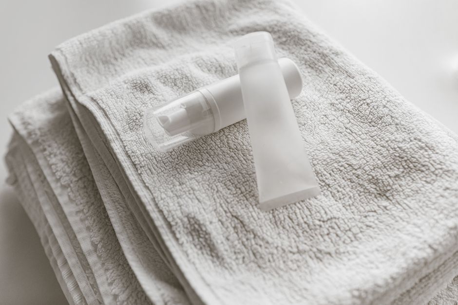 Two toiletries on folded white towels