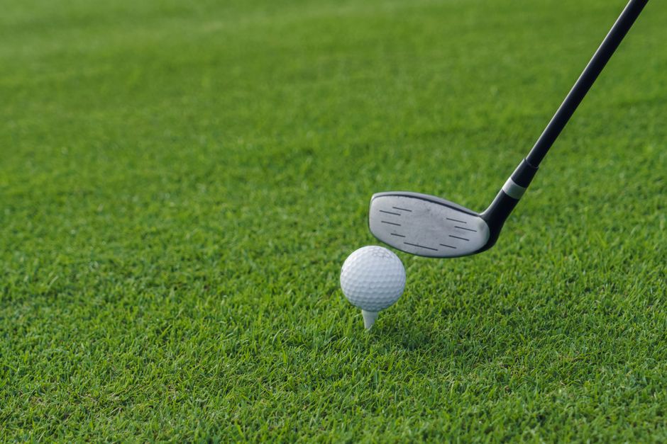Golf club aiming at golf ball on tee