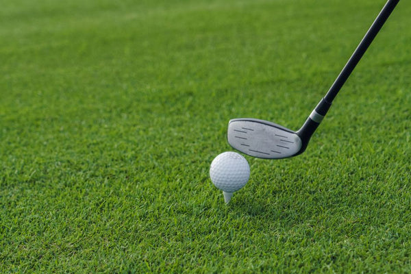 Golf club aiming at golf ball on tee
