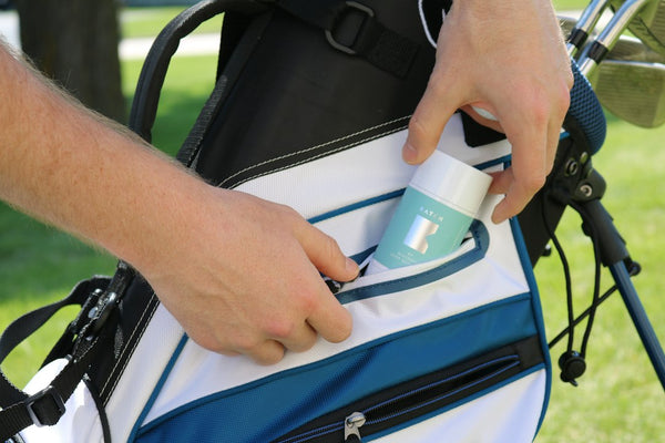 Person placing deodorant into blue golf bag pocket