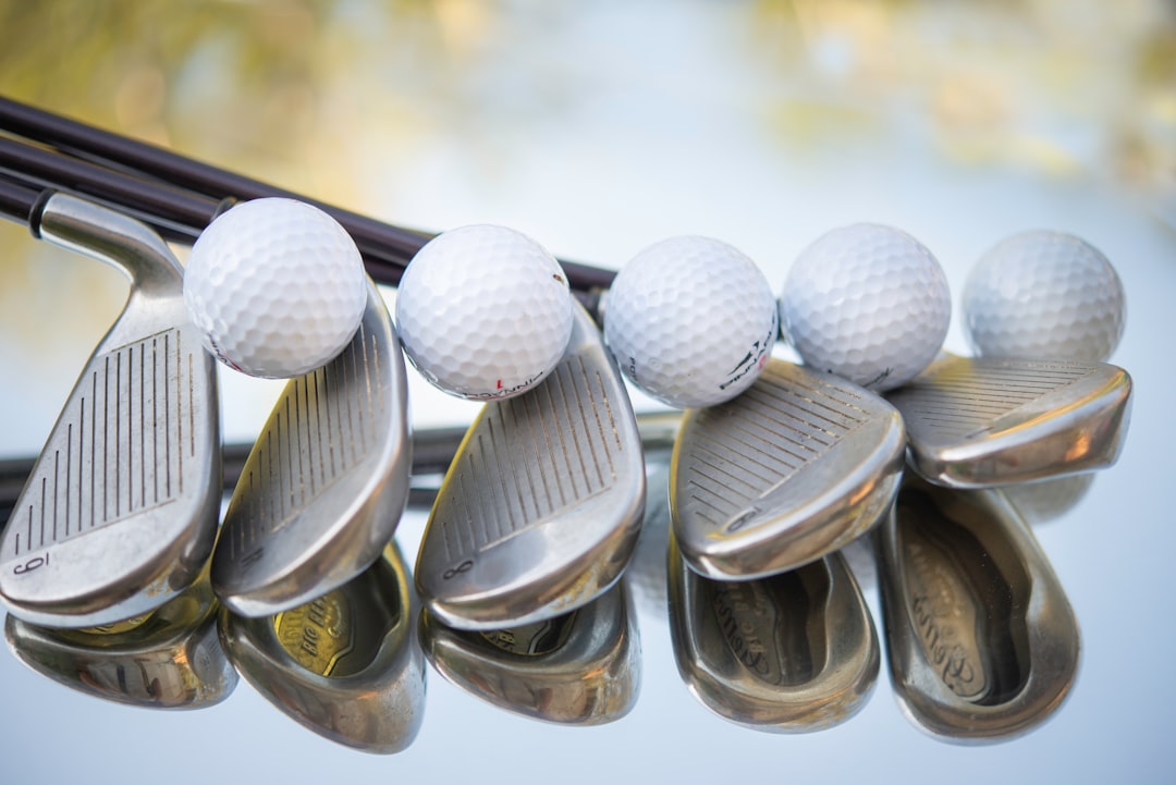 Six golf balls on six iron clubs