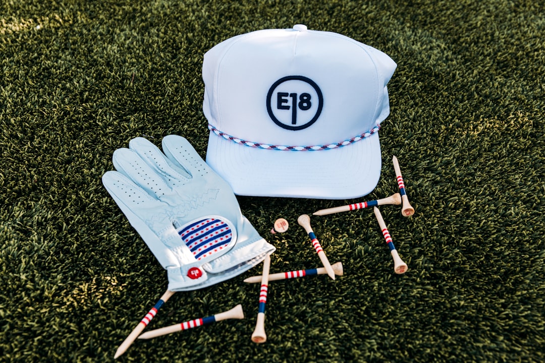 White golf hat glove and tees on grass