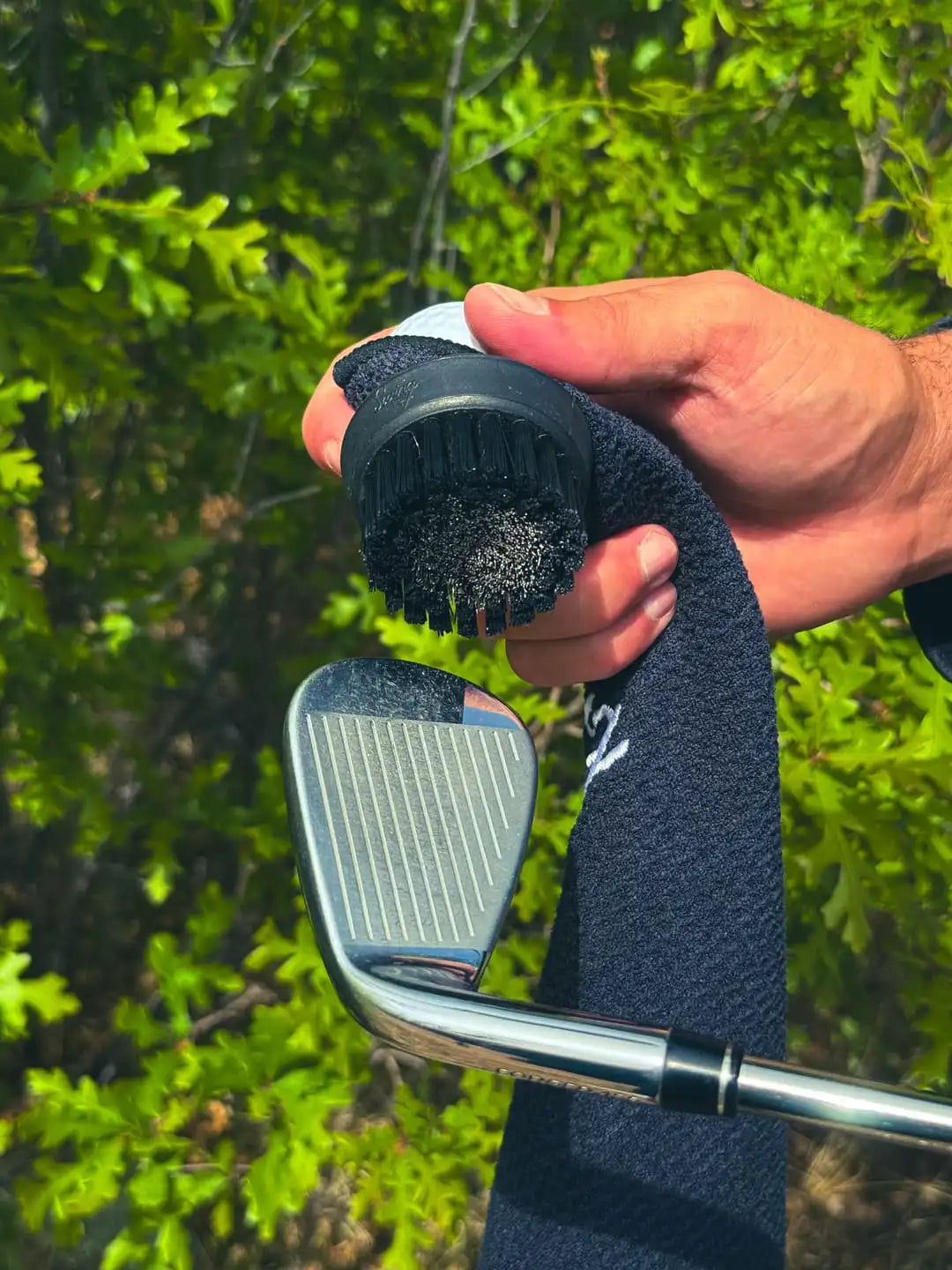Close-up of the Duo Pro steel and nylon hybrid bristle brush head against an iron clubface