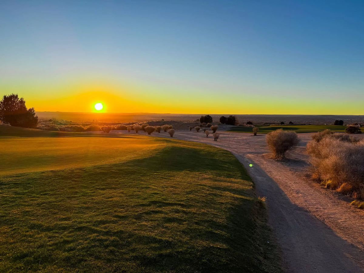 Sun setting over a desert golf course fairway